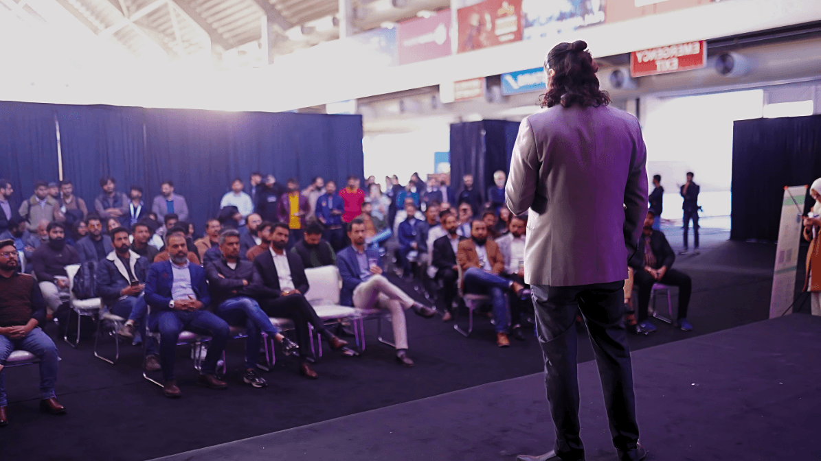 Ahmad Zabir speaking on stage to a room of founders and operators